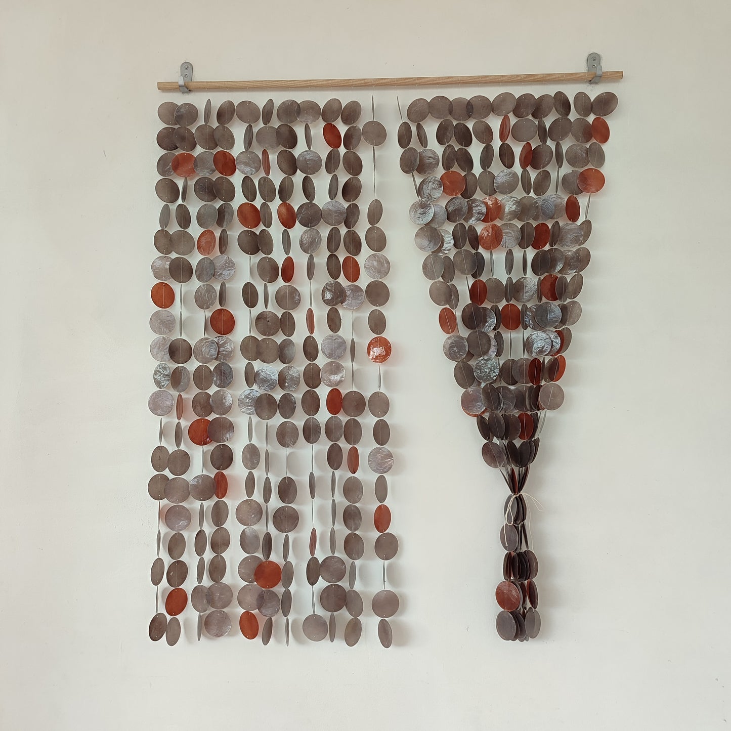 Decorative wall hanging with circular stones on a white background