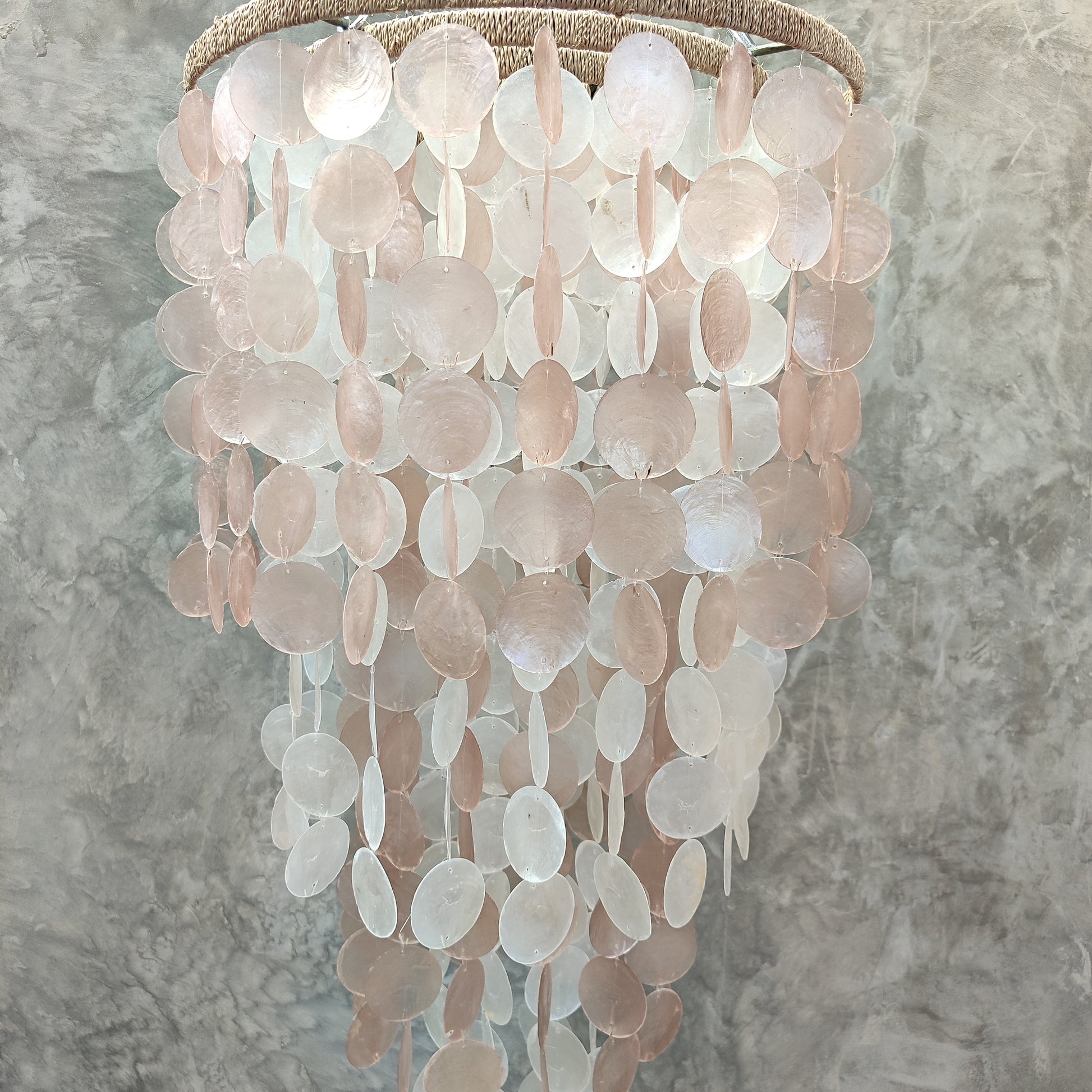 Chandelier made of capiz shell material against a gray background