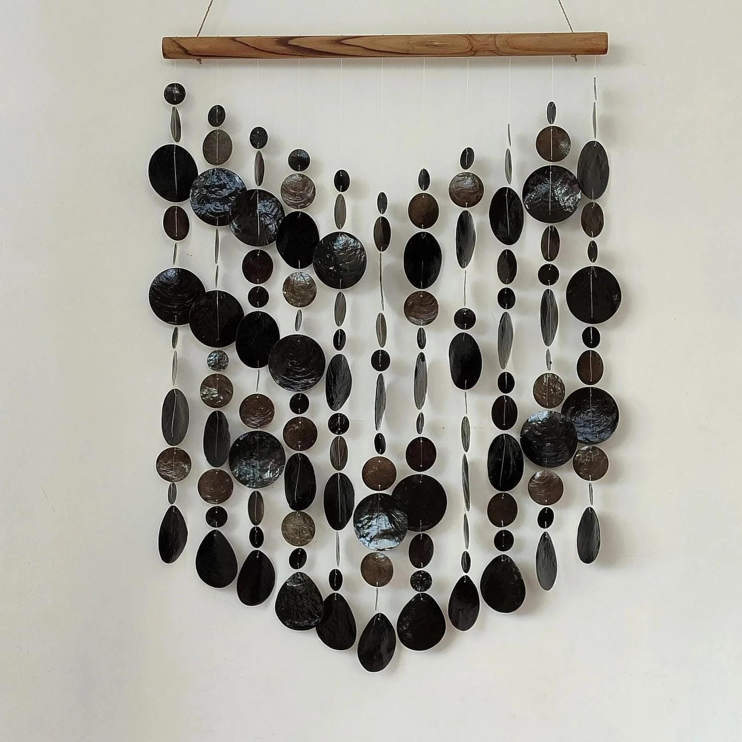 Wall art made of black capiz shell on a white wall