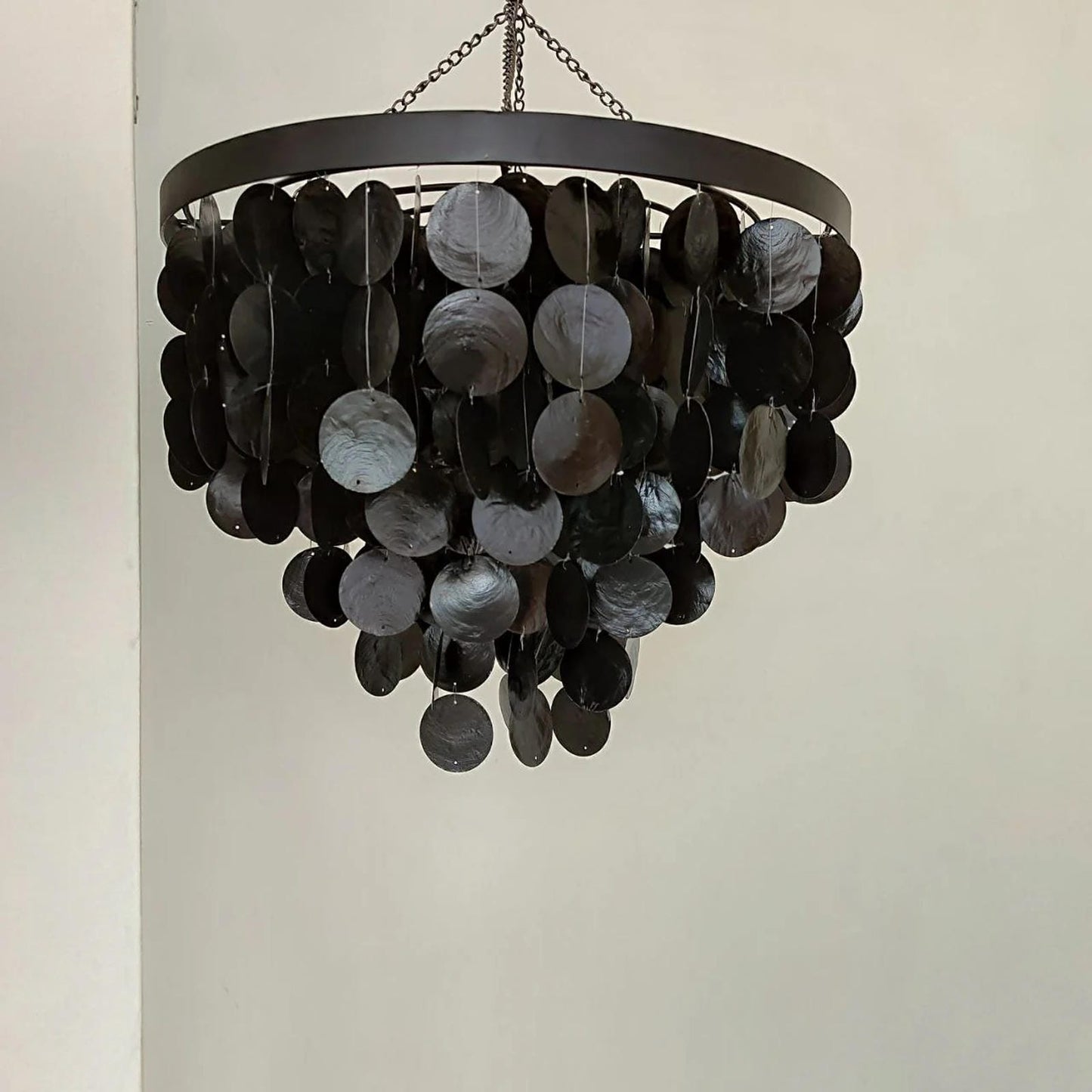 Decorative chandelier with black and gray circular elements on a plain background