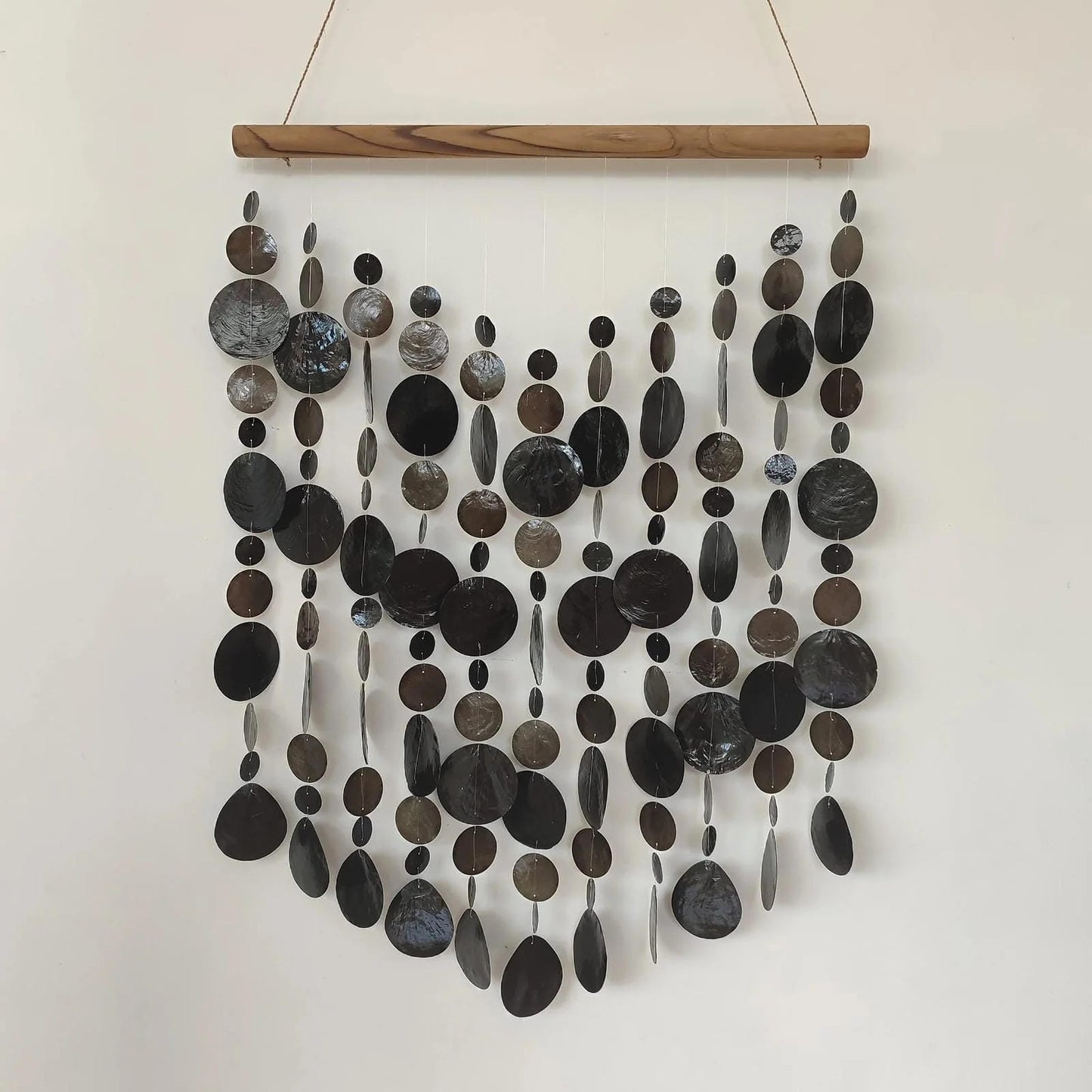 Wall art made of capiz shell on a wooden frame against a white wall