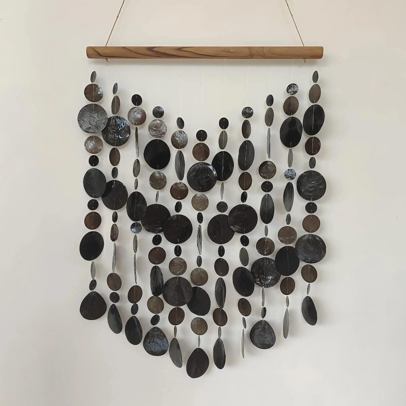 Wall art made of capiz shell on a wooden frame against a white wall