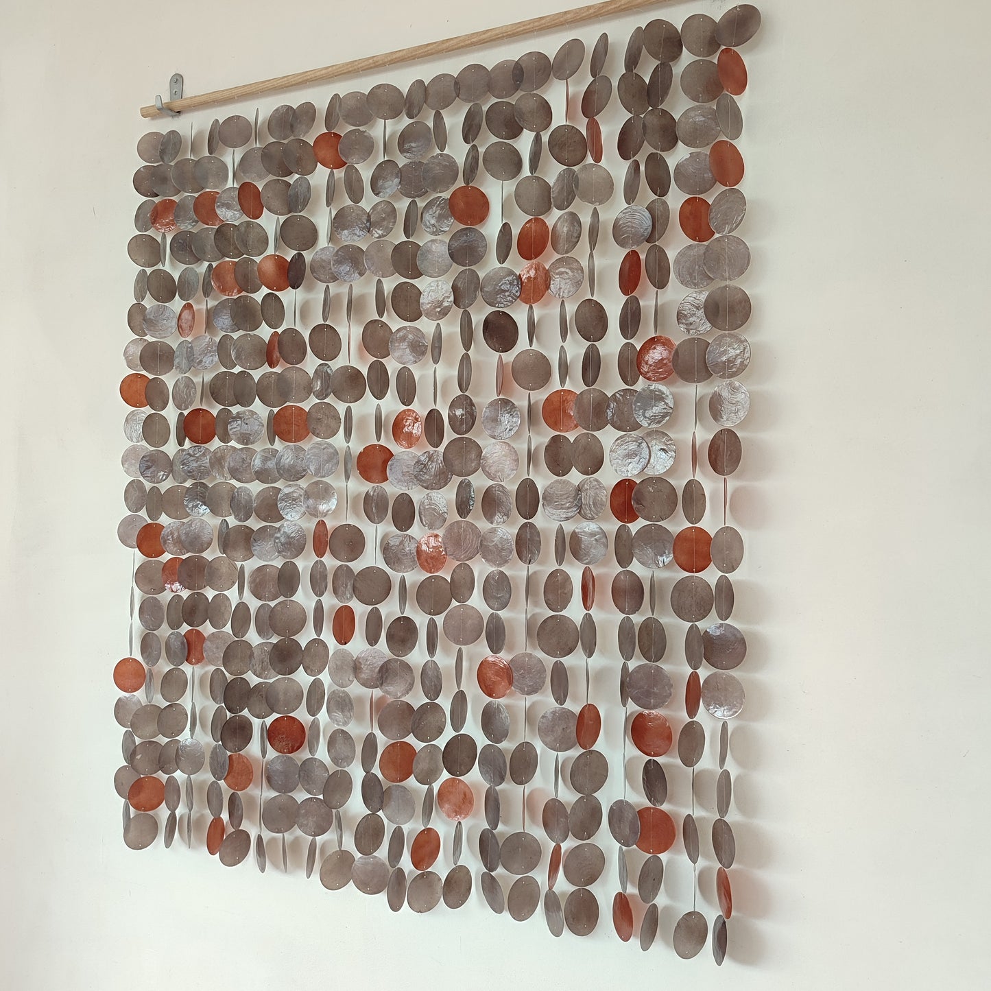 Textile wall art with circular patterns in shades of brown and gray on a white background