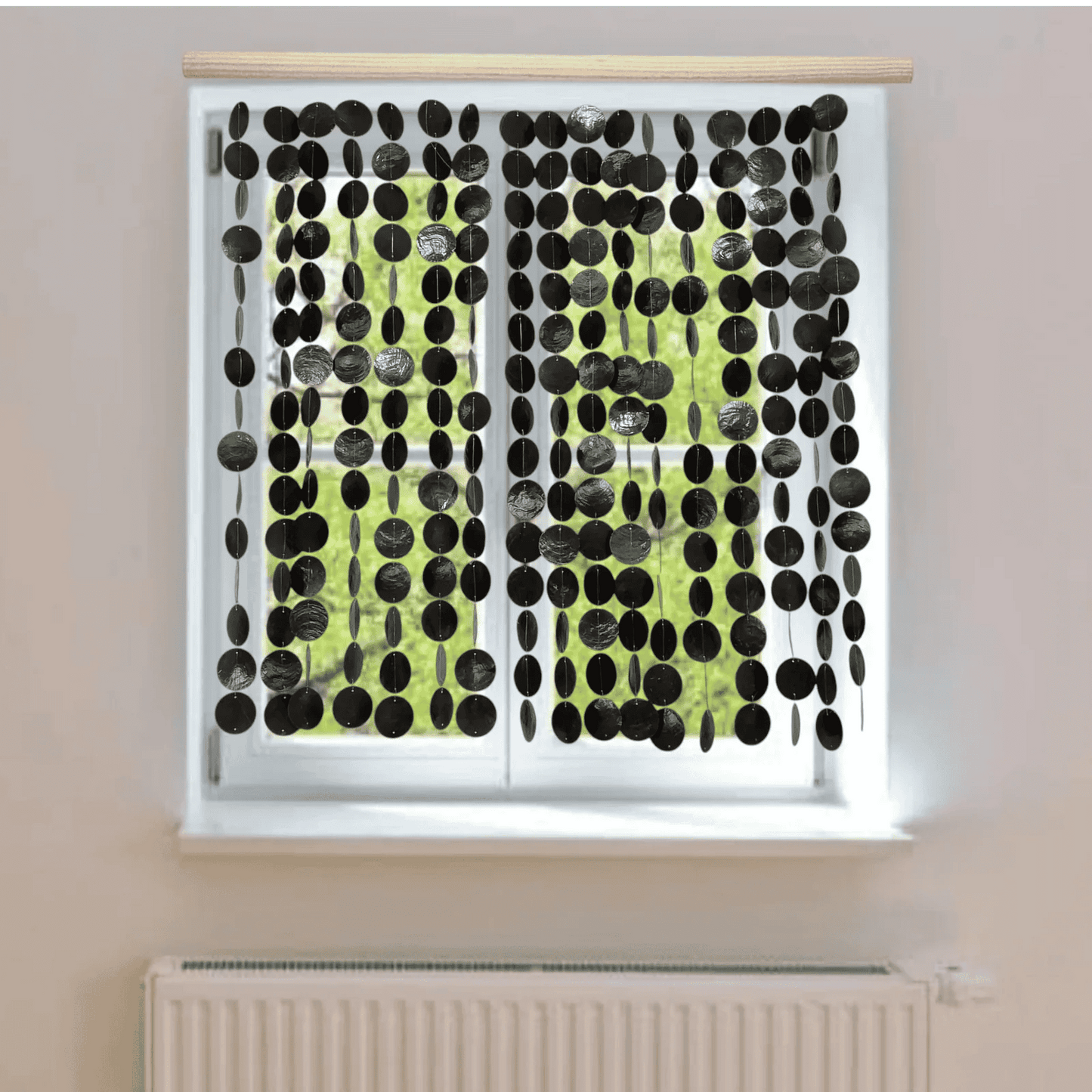 Window with black capiz shell curtain on a light-colored wall