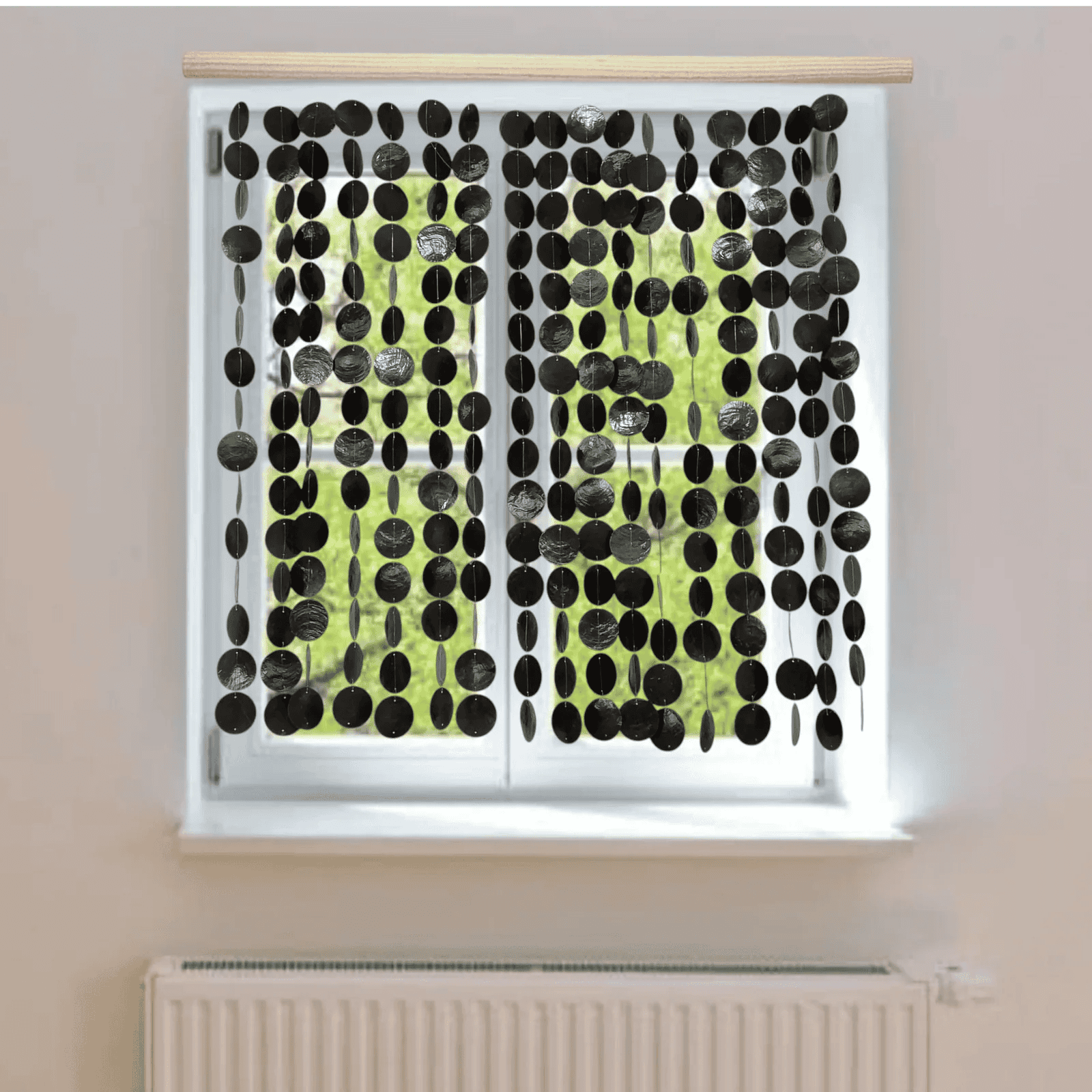 Window with black capiz shell curtain on a light-colored wall