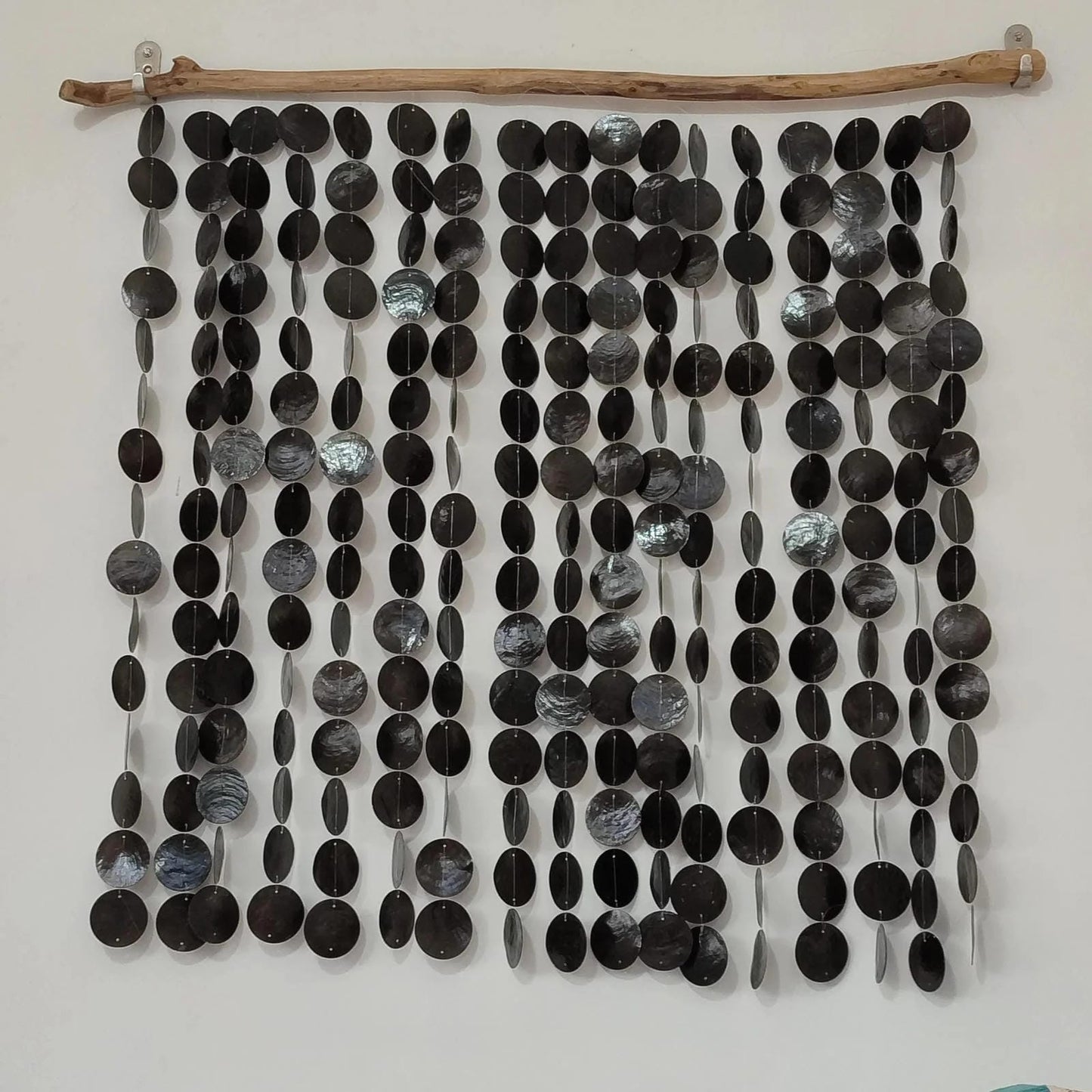 Wall art made of black and gray capiz shell on a white background