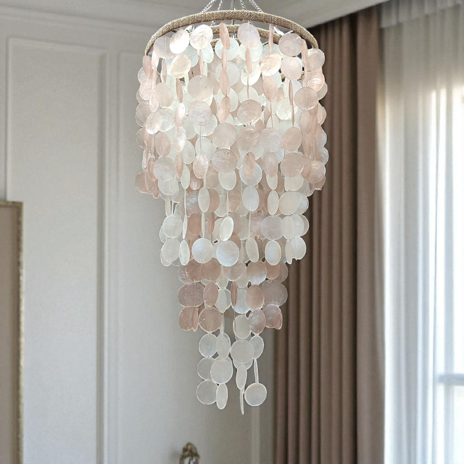 Shell chandelier hanging in a room with neutral decor