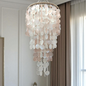 Shell chandelier hanging in a room with neutral decor