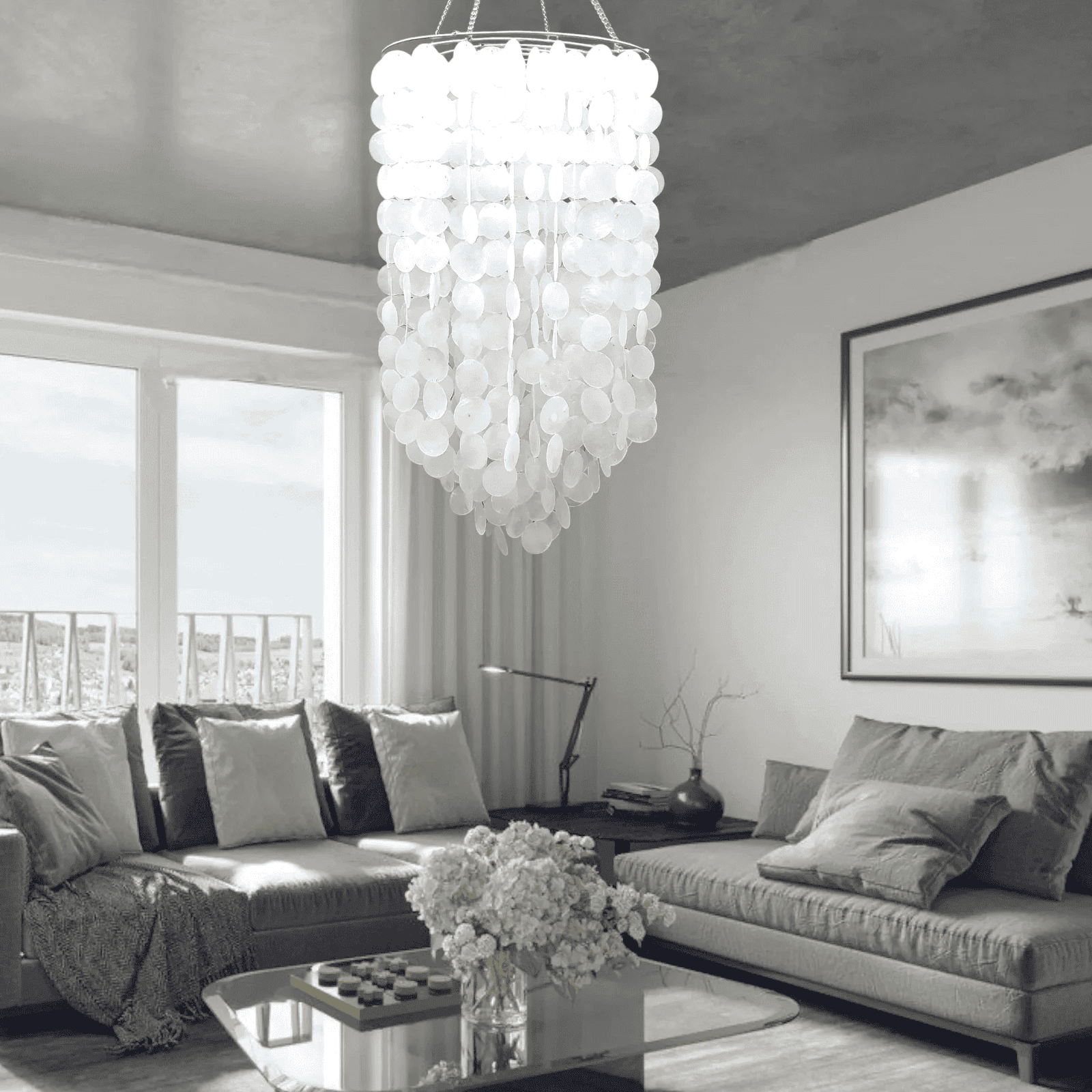 Modern living room with a capiz shell  chandelier, gray sofa, and large windows.
