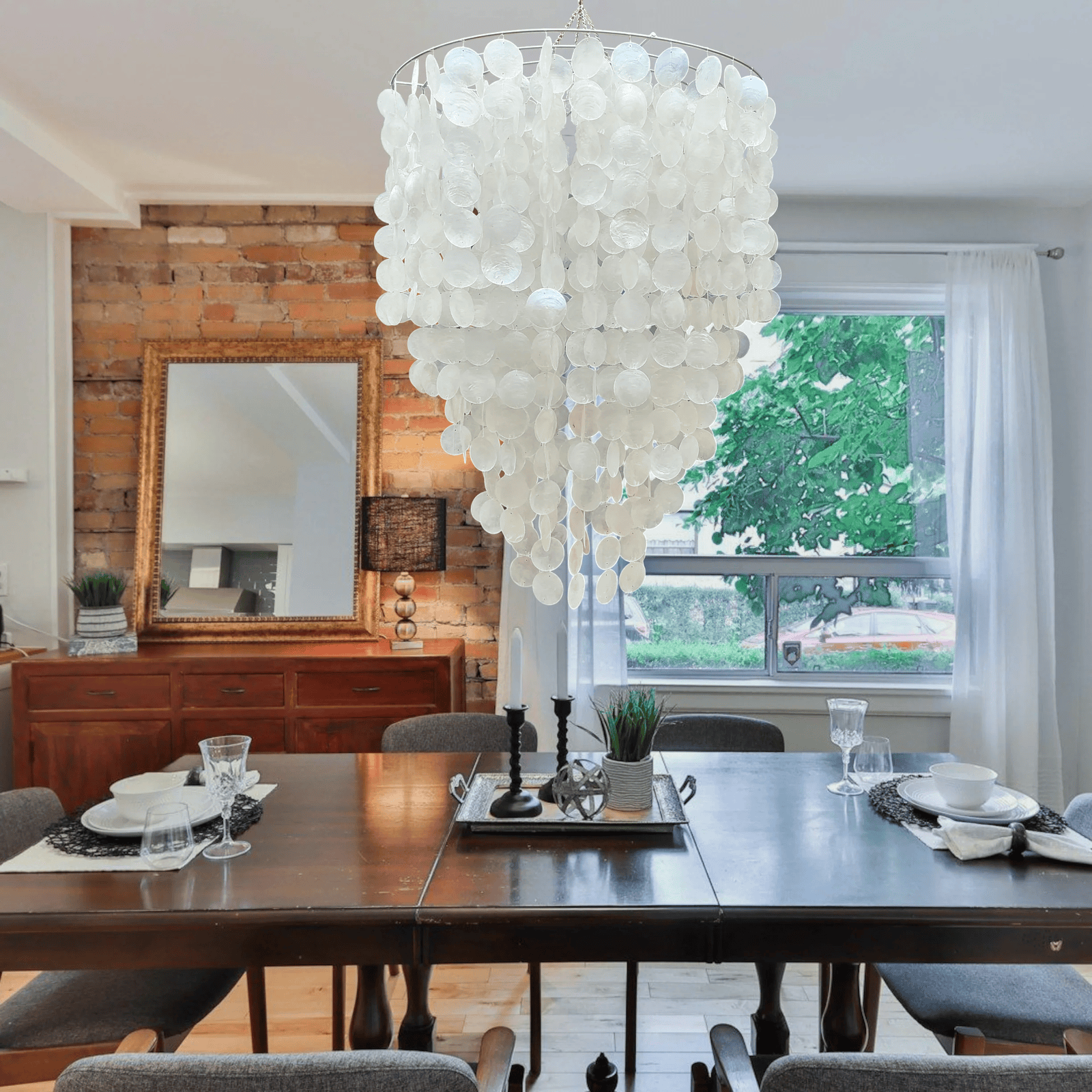 Dining room with a large capiz shell chandelier, wooden table, and chairs.