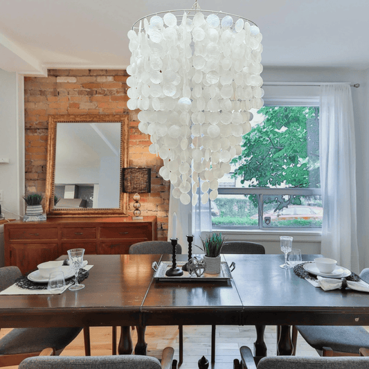 Dining room with a large capiz shell chandelier, wooden table, and chairs.