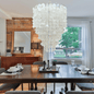 Dining room with a large capiz shell chandelier, wooden table, and chairs.