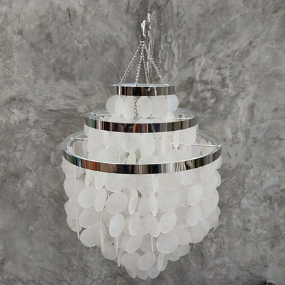 Chandelier with white capiz shell and chrome accents against a gray marble background