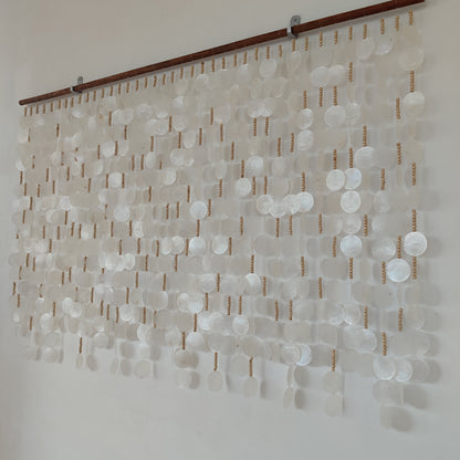 White capiz shell wall art hanging on the white wall