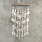 Decorative capiz shellwall hanging with white circular shell on a concrete wall