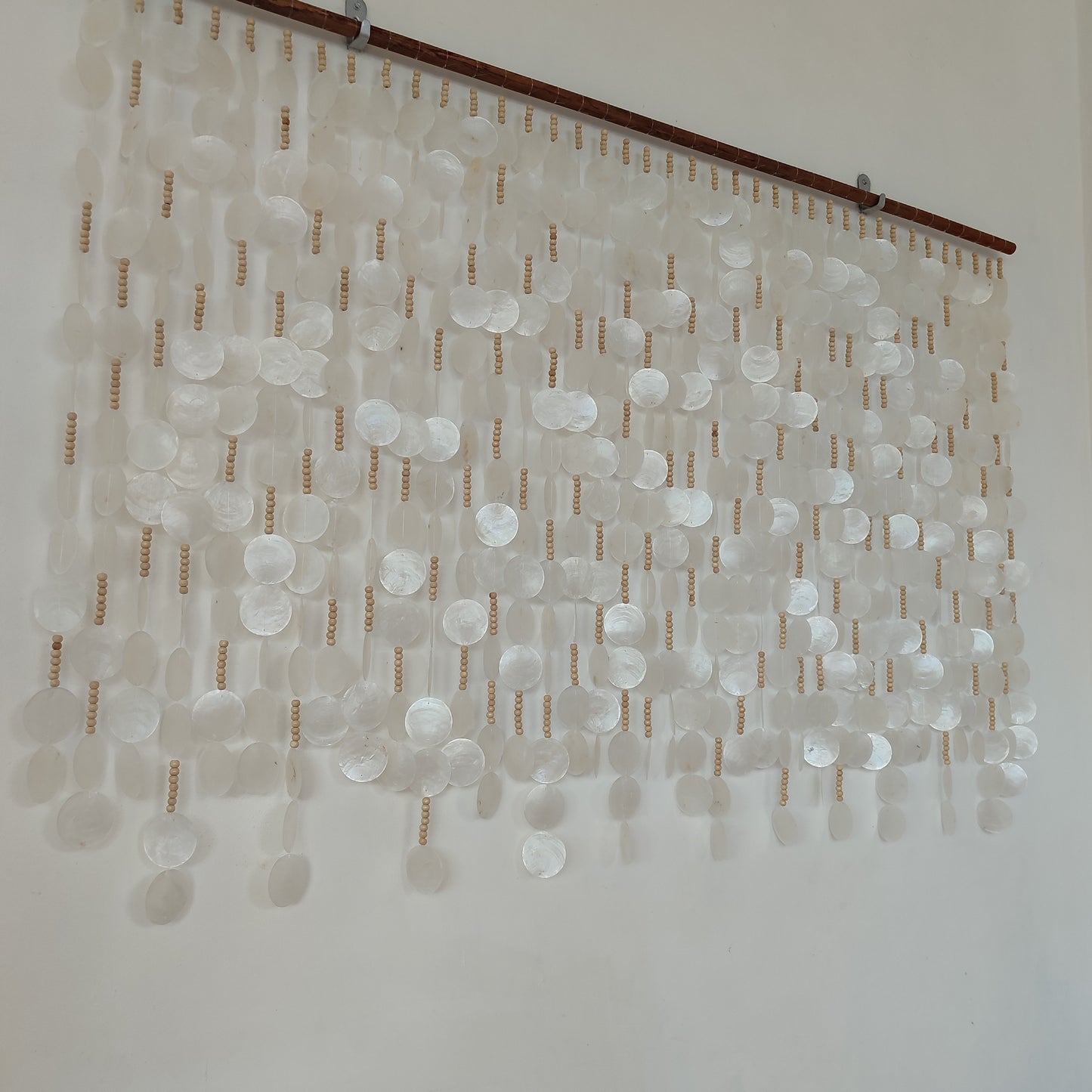 White capiz shell wall decor hanging on the wall from left side