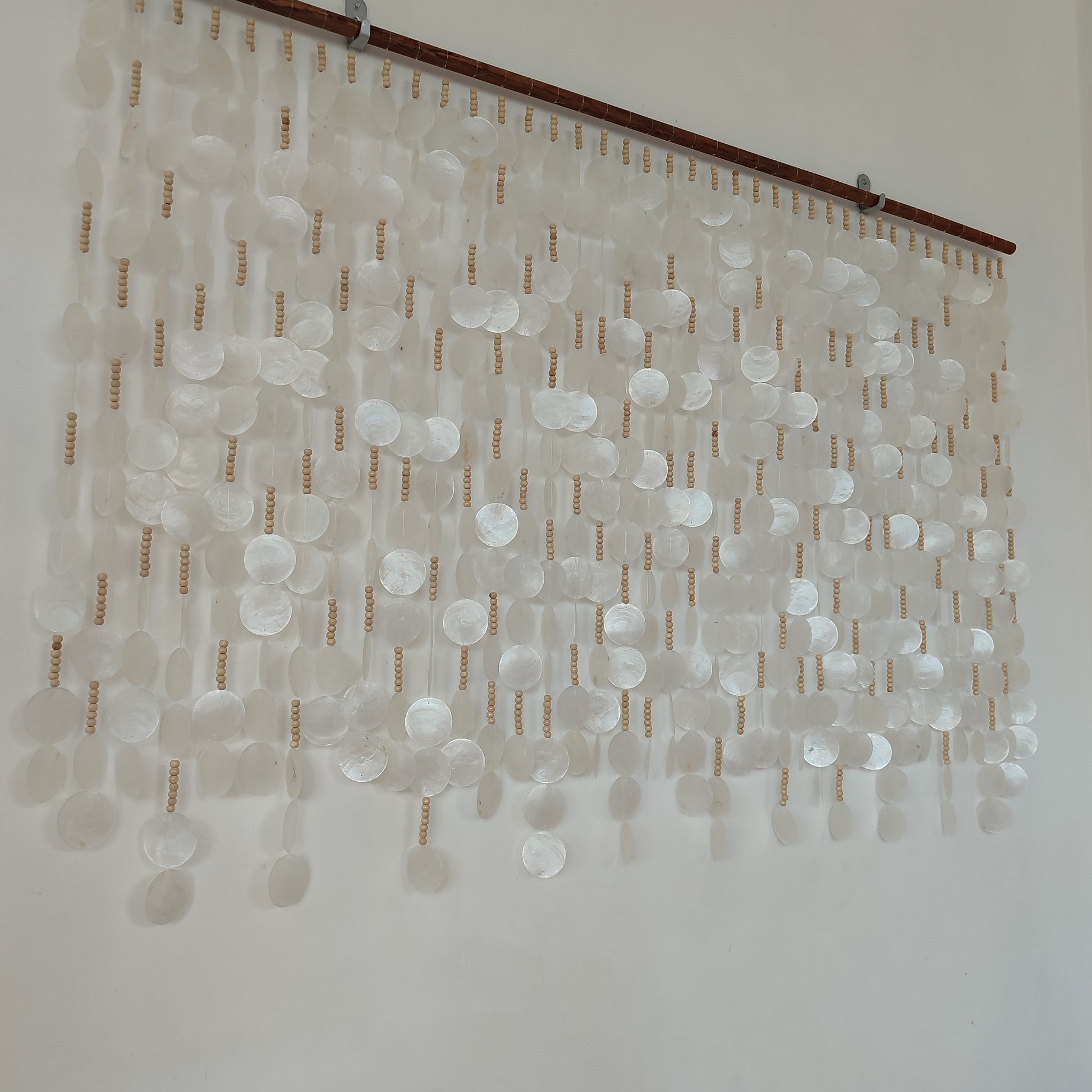 White capiz shell wall decor hanging on the wall from left side