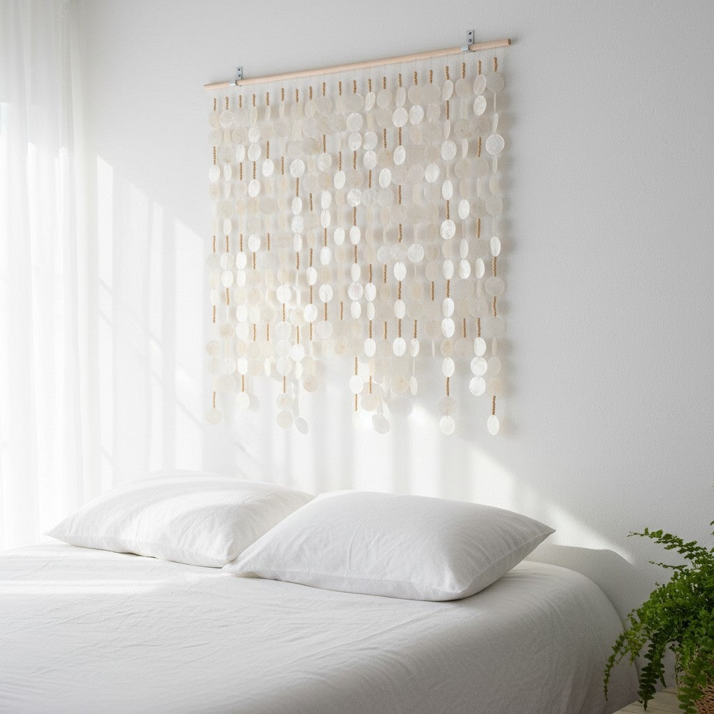 Decorative wall hanging with capiz shell above a bed in a bright room.