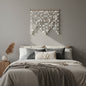 Handmade natural white Capiz shell wall hanging displayed above a neutral-toned bed. The cascading shell strands create a coastal boho statement piece with elegant texture, soft light reflections, and modern organic style