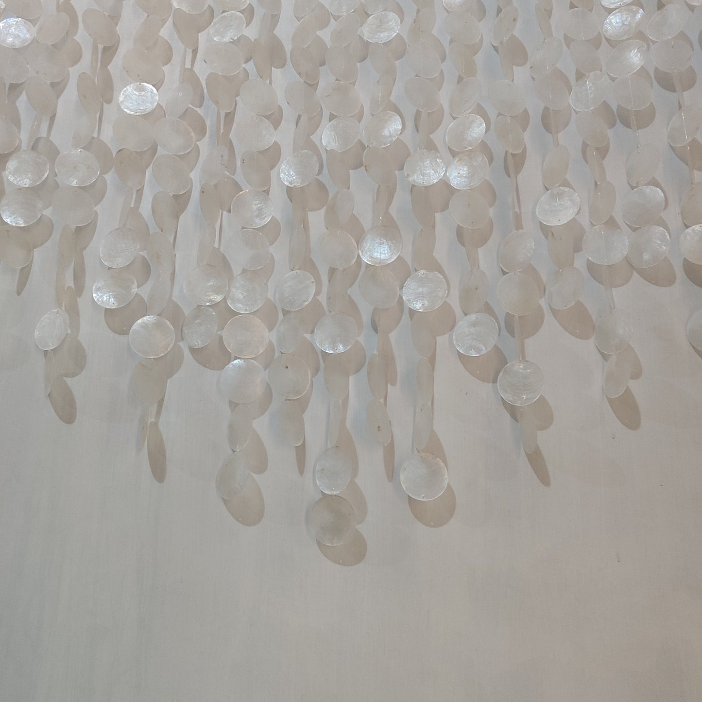 Close-up of a textured wall with hanging beads or similar objects.