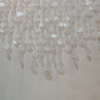 Close-up of a textured wall with hanging beads or similar objects.