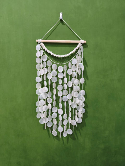 White circular wall hanging on a green background