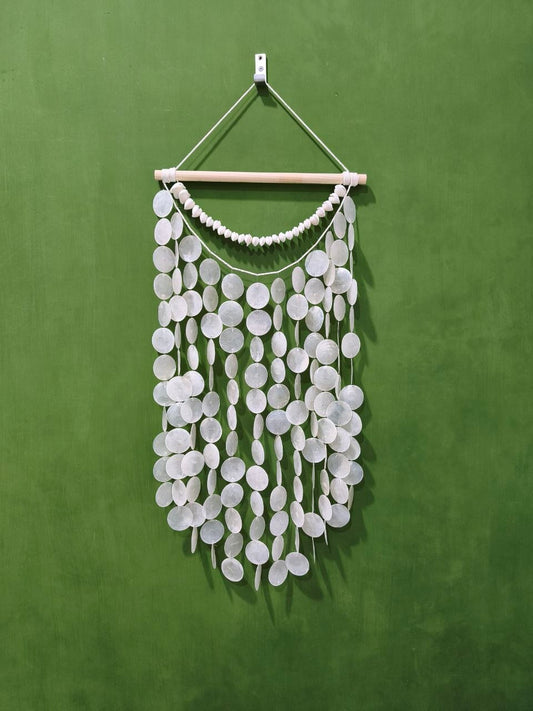 White circular wall hanging on a green background