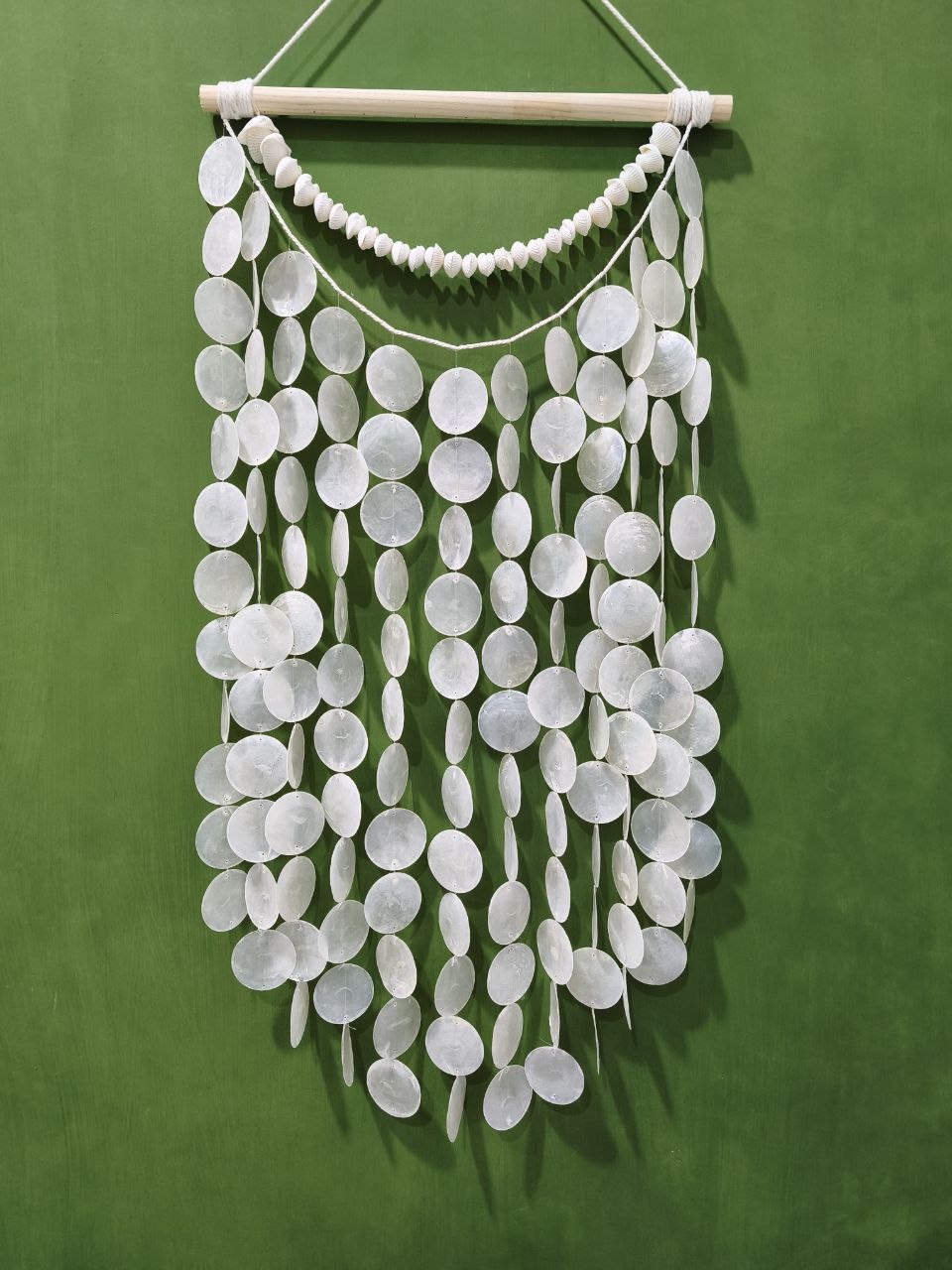 White circular hanging decor on a green background