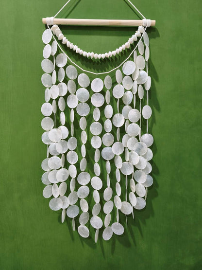 White circular hanging decor on a green background