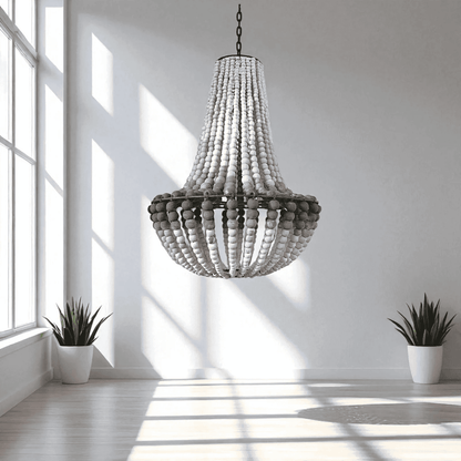 Wooden beaded chandelier hanging in a bright room with two potted plants.