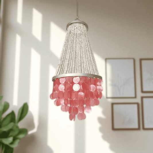 Chandelier with pink capiz shell in a room with framed pictures on the wall.