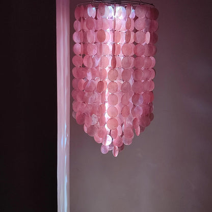 Pink capoz shell chandelier against a neutral wall