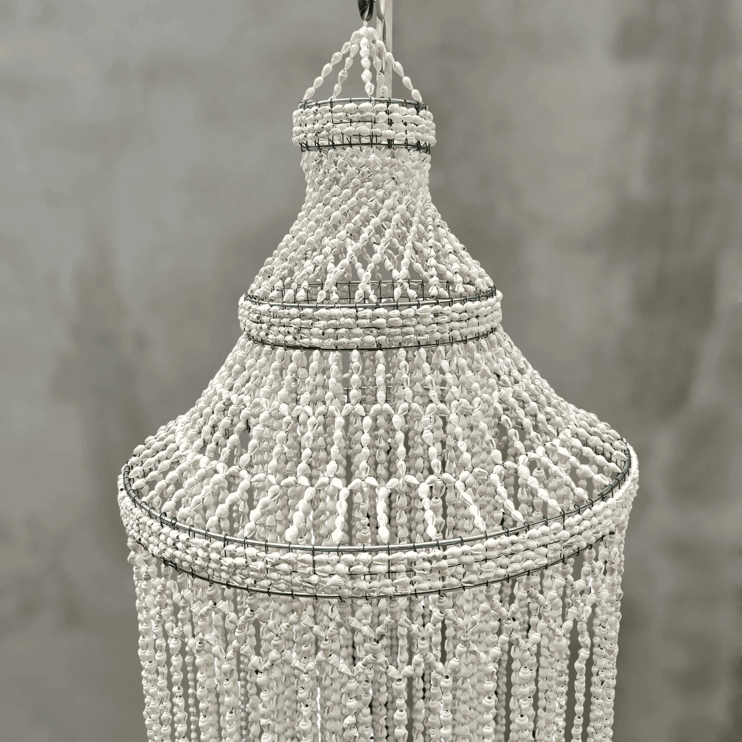 Decorative seashell chandelier against a neutral background