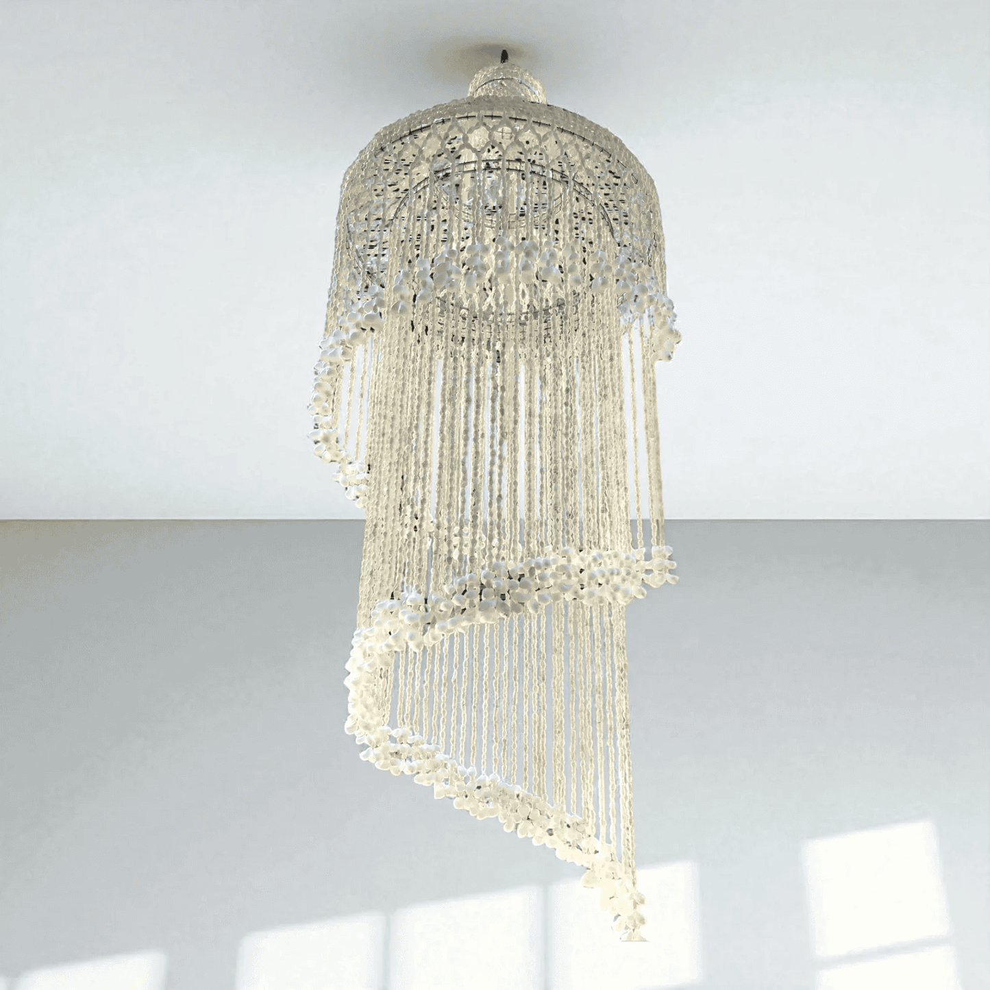 Seashell chandelier hanging from a ceiling with a light gray background
