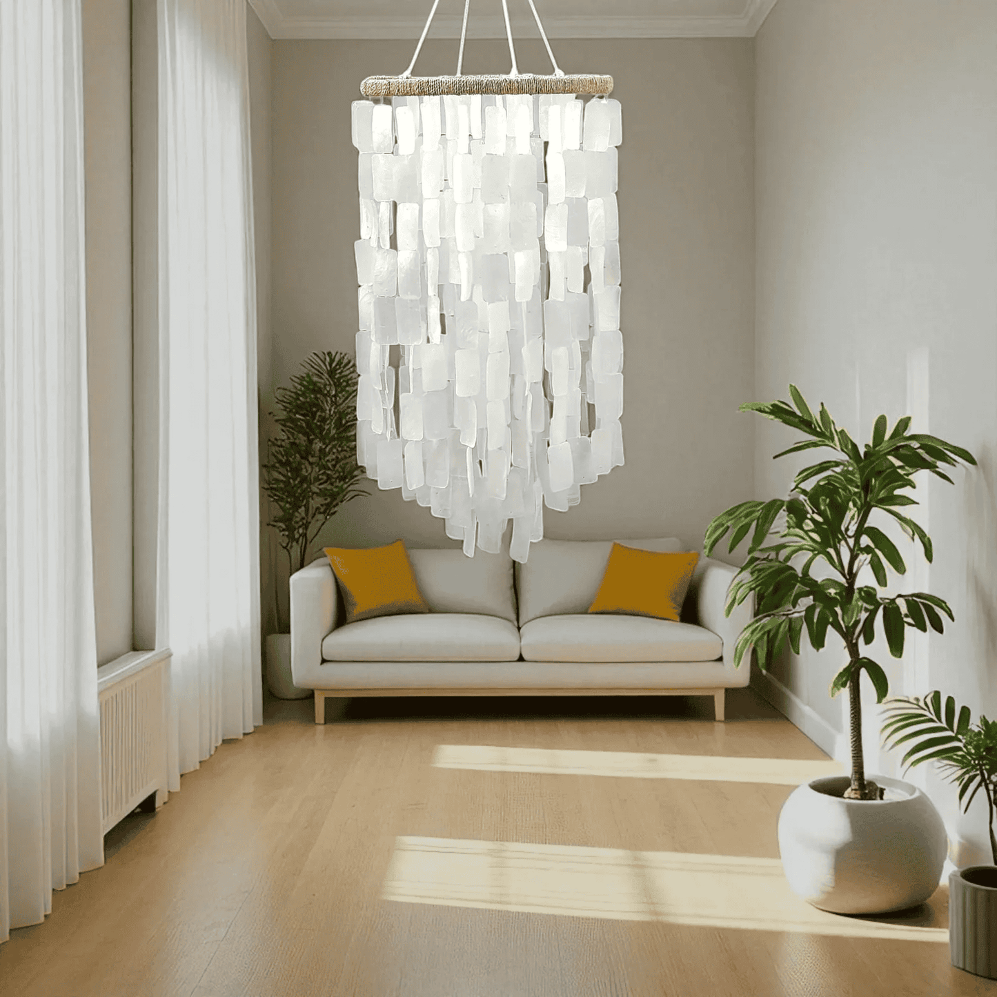 Modern living room with a capiz shell chandelier, sofa, and decorative plants.