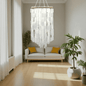 Modern living room with a capiz shell chandelier, sofa, and decorative plants.