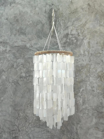Chandelier made of white shell pieces on a gray background