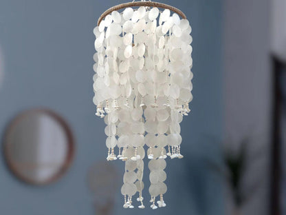 White capiz shell chandelier against a blue wall