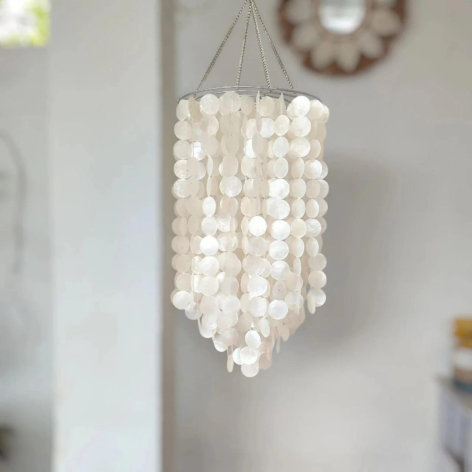 White Capiz shell chandelier hanging against a neutral background