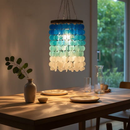 Dining room with a colorful pendant light fixture, table setting, and window view.